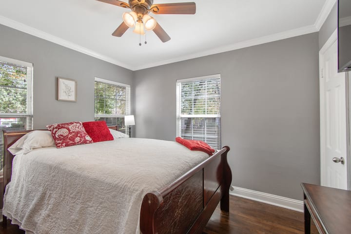 Dormitorio medio con ventanas que dan al patio trasero vallado; incluye TV inteligente de alta definición de 50pulgadas.