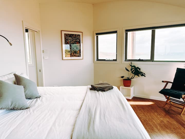 Master bedroom upstairs with a side view of the room, including newly installed artwork. 