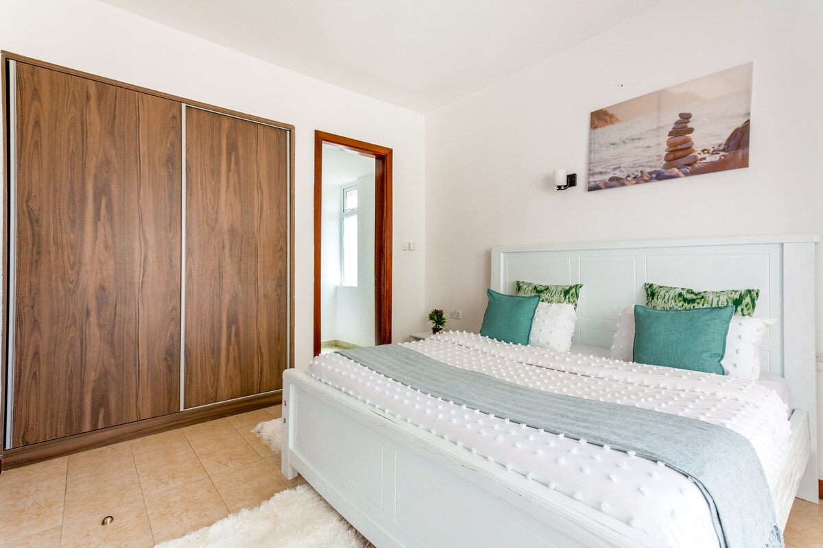 Брачна спална соба во Килимани со гардероба од подот до таванот, мирна ѕидна уметност и минимален дизајн. Идеално за парови или самостојни гости. Стилски, светло и во близина на националниот парк Најроби, Вестлендс и ЈКИА. Исчистете ја удобноста во модерен амбиент.