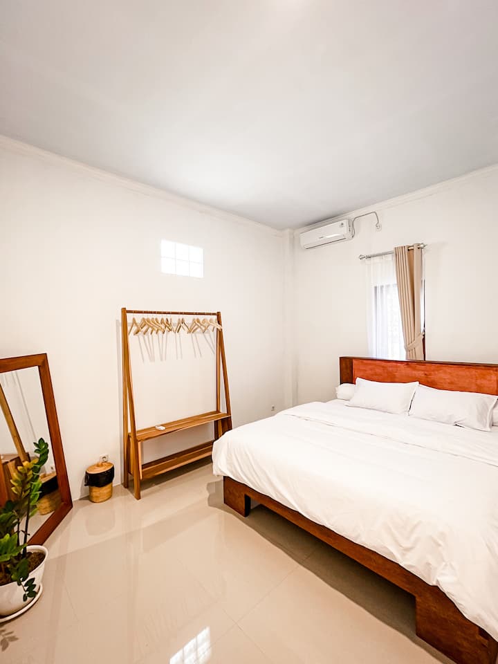 Dormitorio con cama tamaño king, aire acondicionado y armario abierto