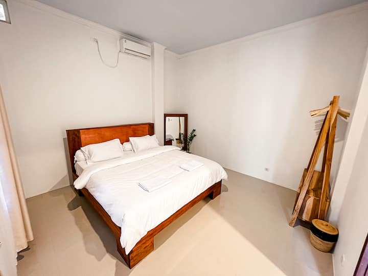 Dormitorio con cama tamaño king, aire acondicionado y armario abierto