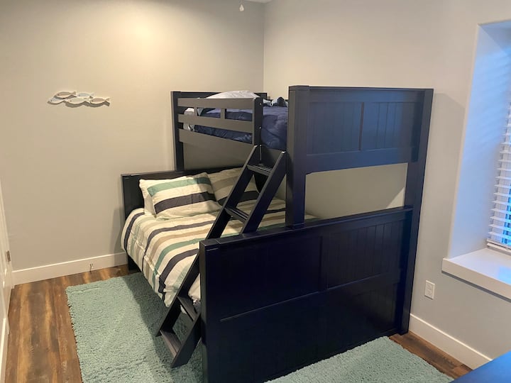 Queen bed with twin bunk on top and twin pull out mattress under bed.