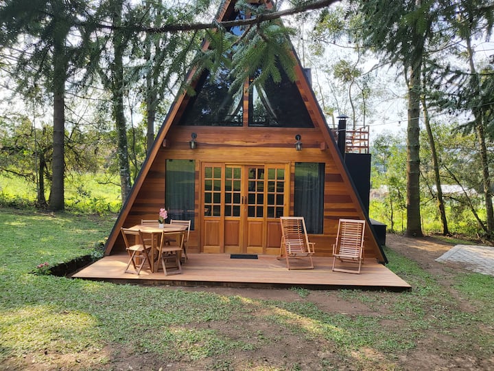 Varanda do chalé A-frame de madeira com cadeiras, na Colônia Witmarsum