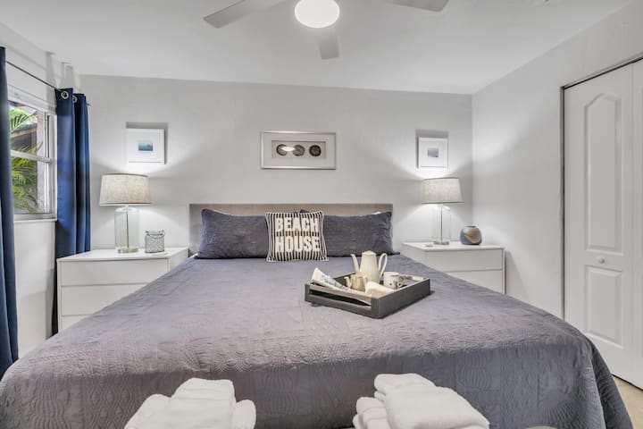 Hoofdslaapkamer met King Sealy-matras, plafondventilator en werkplek.  De kast is voorzien van kleerhangers en een bagagerek.