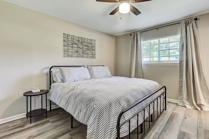 Colchón NUEVO tamaño king del dormitorio 1. Edredón de estilo hotel, funda  y sábanas. Persianas y cortinas que oscurecen la habitación. Ventilador de techo para el control de temperatura. Los huéspedes de la televisión inteligente (no se muestran en la foto) que inician sesión en los servicios de streaming. 