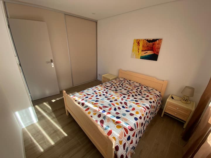 Chambre de couple avec volets occultants et armoire intégrée avec beaucoup de rangement.