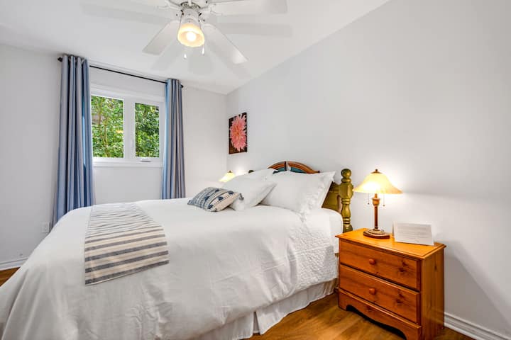 A queen bed, with bath towels and make up towels.