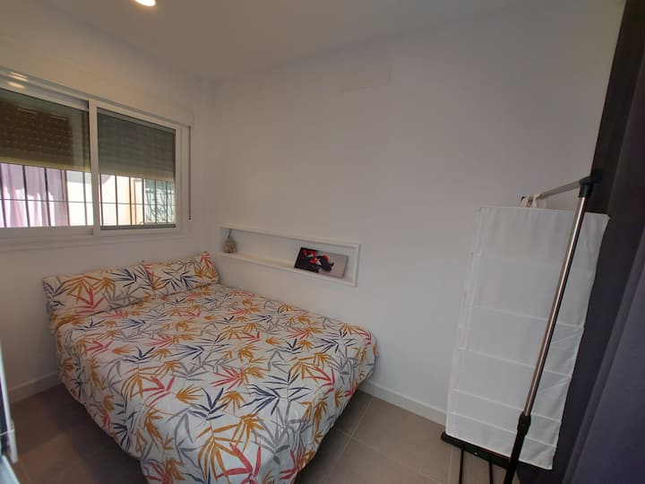 Cama de 1,35 en dormitorio con ventana a la calle .
