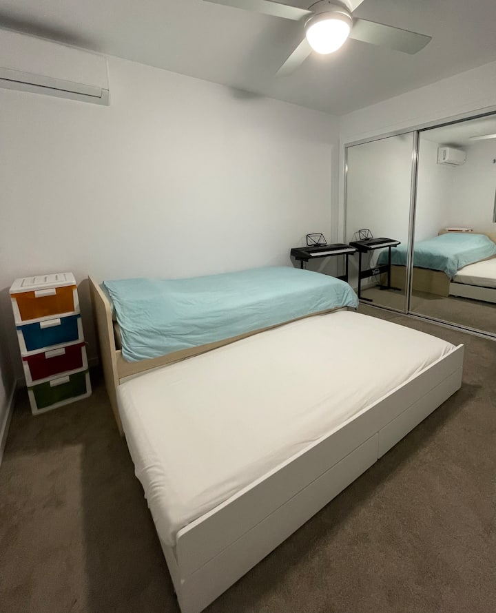 חדר שינה עם מיטת יחיד ומיטה מתקפלת אחת.