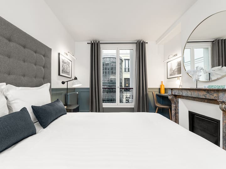 EN : Chumba cha kulala cha kwanza kilicho na kitanda cha watu wawili, mashuka, sehemu ya kufanyia kazi na mwonekano juu ya ua / 
FR: Chumba cha kulala cha kwanza kilicho na kitanda cha watu wawili, matandiko, sehemu ya kufanyia kazi na mwonekano wa ua
