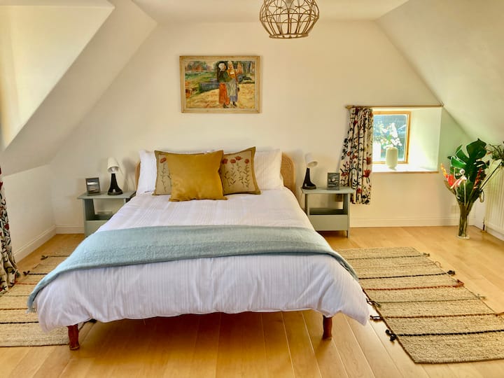 Chumba kikubwa cha kulala chenye nafasi kubwa chenye sehemu ya kukaa.