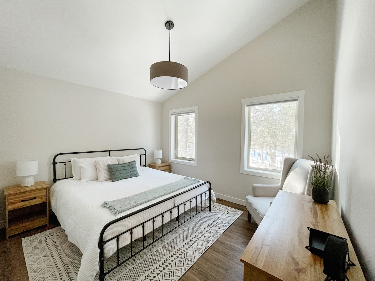 Hlavná spálňa na hlavnom poschodí s výhľadom na les.
