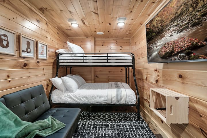 La habitación doble de nivel inferior sobre la litera completa tiene un televisor inteligente Roku y espacio para acurrucarse para las historias antes de acostarse.