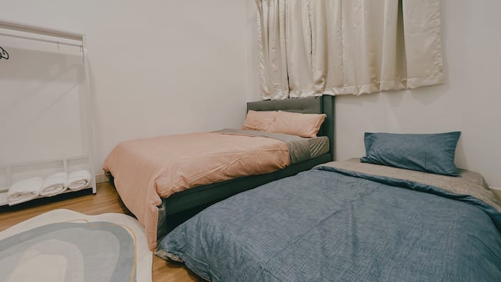 Spálňa s jednou manželskou posteľou a jedným matracom na podlahe 