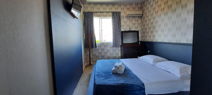 Ოთახი დიდი საწოლით, გაყოფით, ტელევიზორით, გარდერობით