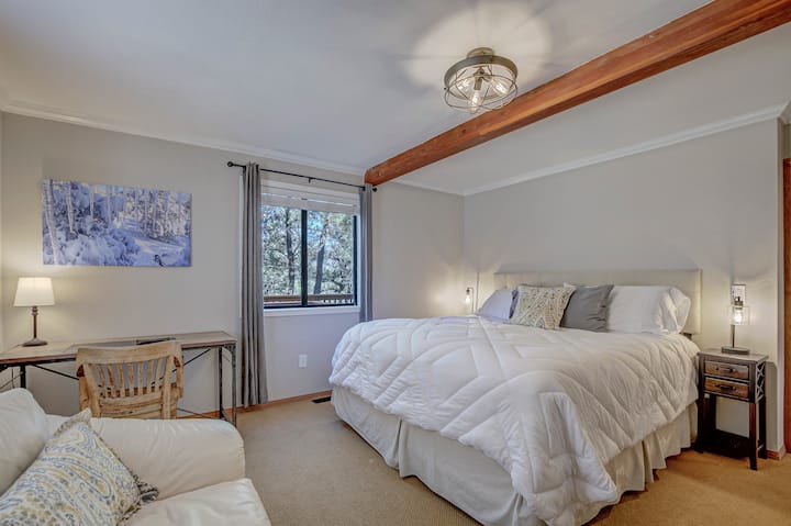One of the main floor bedrooms. King bed, comfy chair, and a private workspace.