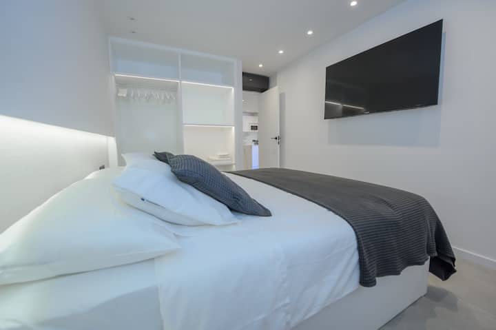 Dhomë gjumi kryesore me krevat dopio "king size" (180x200), televizor 55 4K,ajër të kondicionuar, dhomë zhveshjeje të ndriçuar dhe dritare për në tarracë me grila të tejdukshme dhe opak automatik.