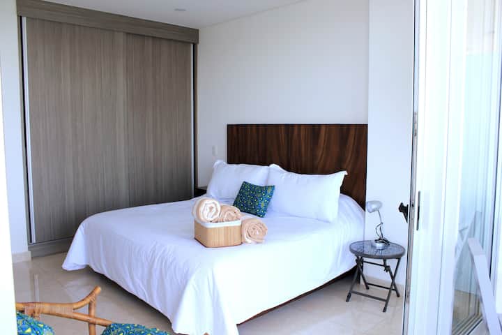 Glavna spavaća soba s bračnim krevetom i pogledom na ocean.  Smart TV 65°