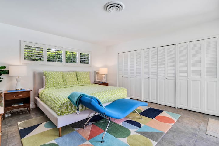 เตียงขนาดคิงไซส์และเลานจ์เก้าอี้ที่อบอุ่นในห้องนอนหลักที่มองออกไปเห็นสระว่ายน้ำและลานบ้าน ที่นอน Tuft & Needle ใหม่ล่าสุดสมาร์ททีวีขนาด 55 ฟุตพร้อม Roku