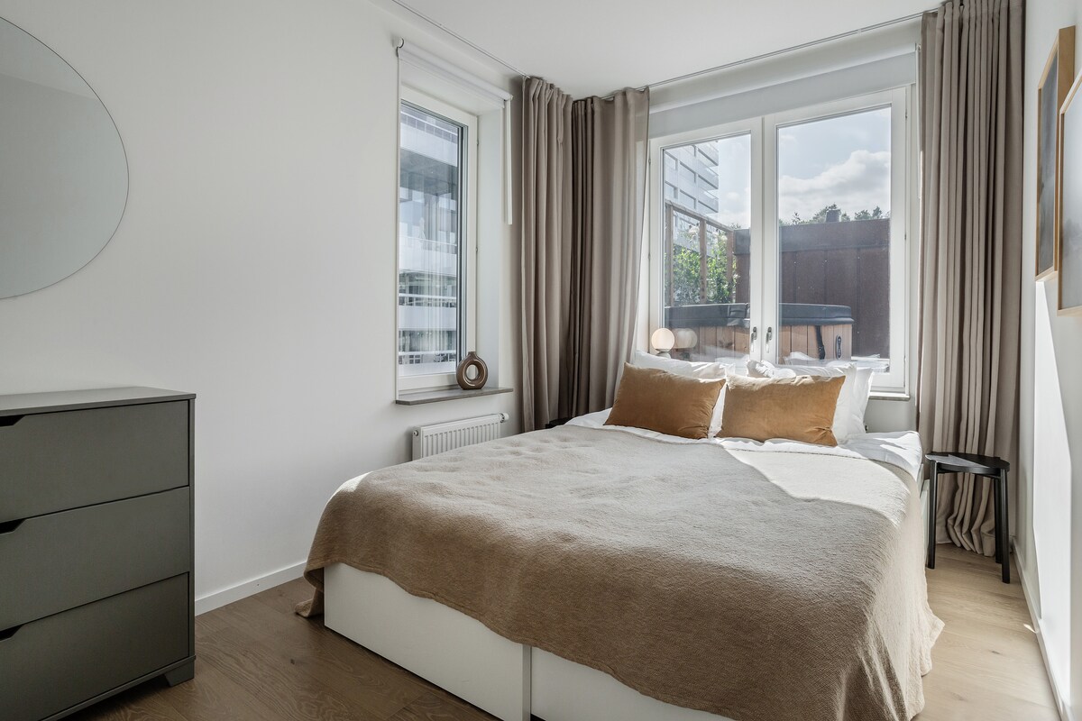 可欣赏热水浴缸和露台美景的卧室