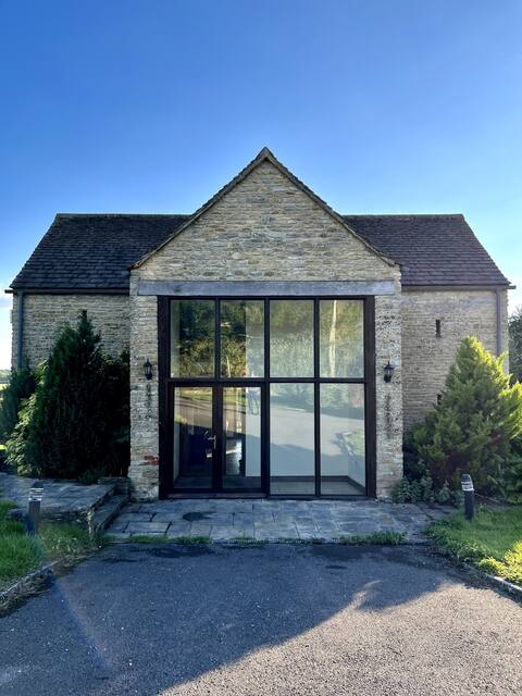 Cotswold home with a fireplace overlooking fields.