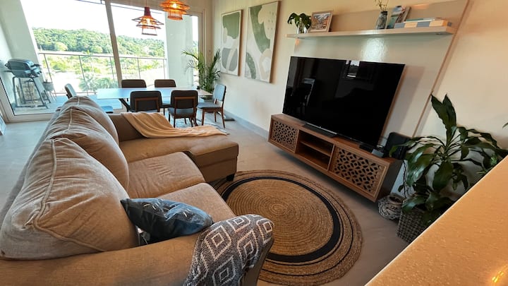 Sala con TV OLED 65” para noches de películas. Este es el SOFÁ CAMA (colchón Queen) que usarían los huéspedes #5 y #6