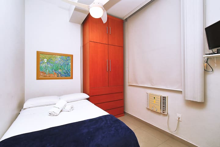 Spavaća soba 3 suite s bračnim krevetom, klima-uređajem, TV-om, ormarićima i stropnim ventilatorom.