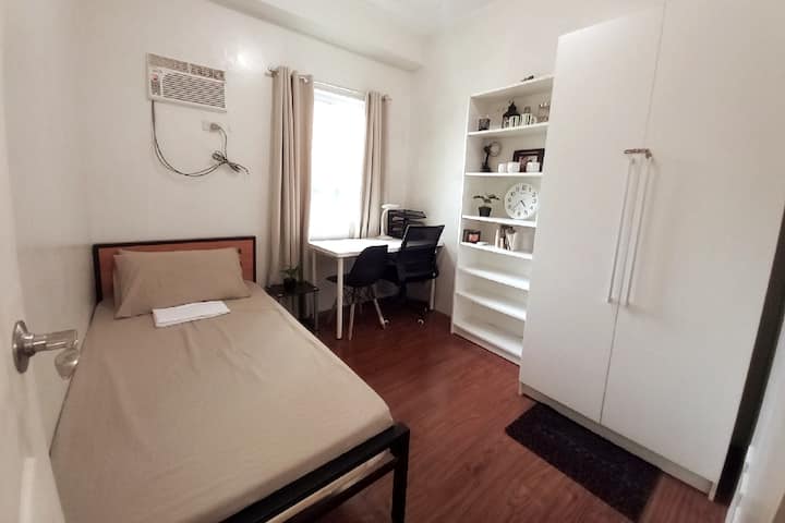 Ova soba ima krevet za jednu osobu, ormarić i radni prostor s ergonomskom stolicom.