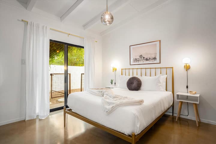 Chumba cha kulala cha Master - kitanda cha malkia na sliders kwenye eneo la baraza lililofunikwa.