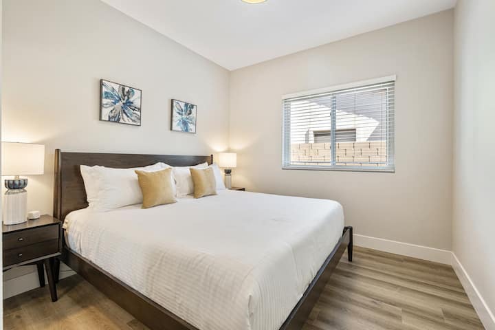 מיטת קינג סייז בקומה הראשית עם חדר רחצה ושירותים לצד חדר השינה