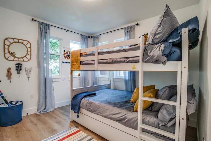 غرفة بطابقين مع سريرين كاملين وسرير مزدوج في الأسفل.