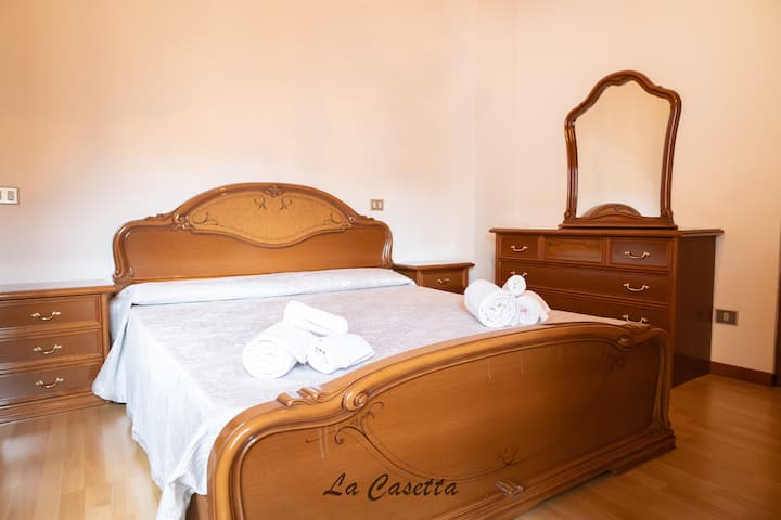 Double bed: The room is equipped with a double bed with wooden headboard, complete with clean and quality bedding.