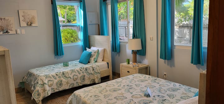 Druga spavaća soba u prizemlju s estetikom karipskog stila. Ima jedan jednostruki i jedan bračni krevet (160x200), klima-uređaj, ventilator i privatnu kupaonicu