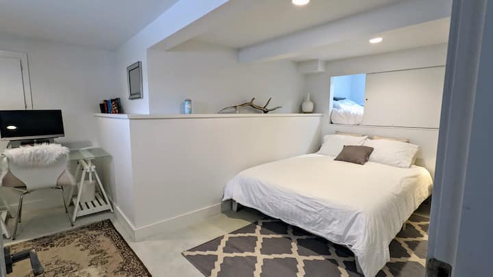 Krevat dopio "qoshe" në katin e poshtëm me një krevat dopio "qoshe" në mur.  Tavolinë pune dhe monitor.