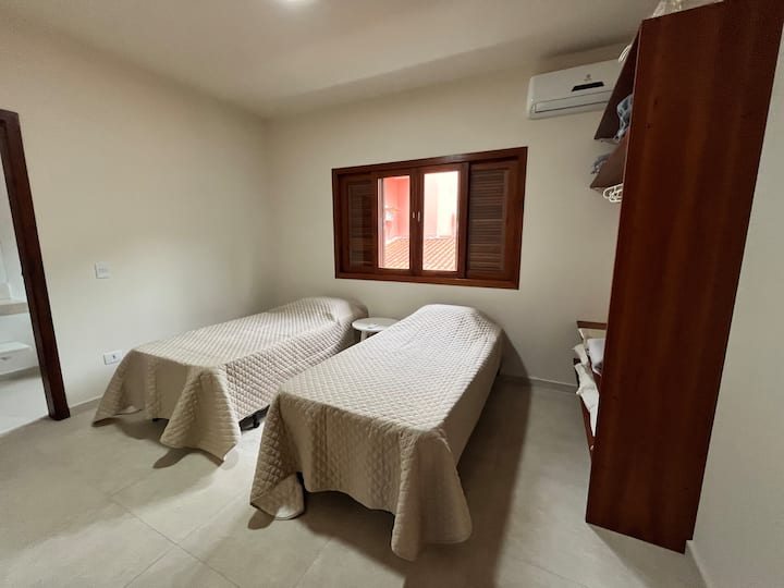 Suite 5 con 2 camas individuales que forman juntos una cama doble y armario.