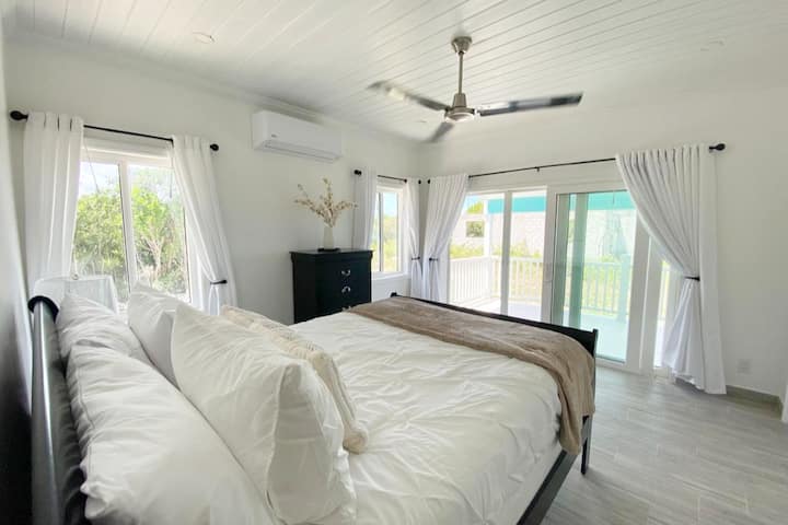 Bedroom 2 with queen size bed, large windows, and doors to the balcony