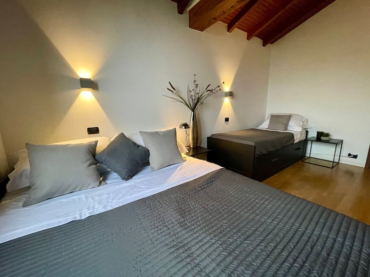 Slaapkamer met tweepersoonsbed en één eenpersoonsbed.