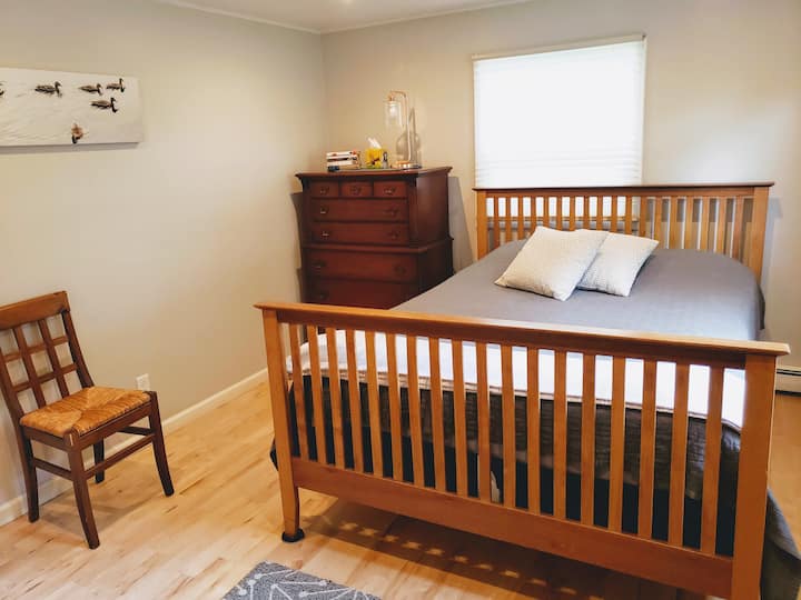 La chambre du milieu dispose d'un lit Queen Size de style artisanal, de deux fenêtres et d'un grand placard.