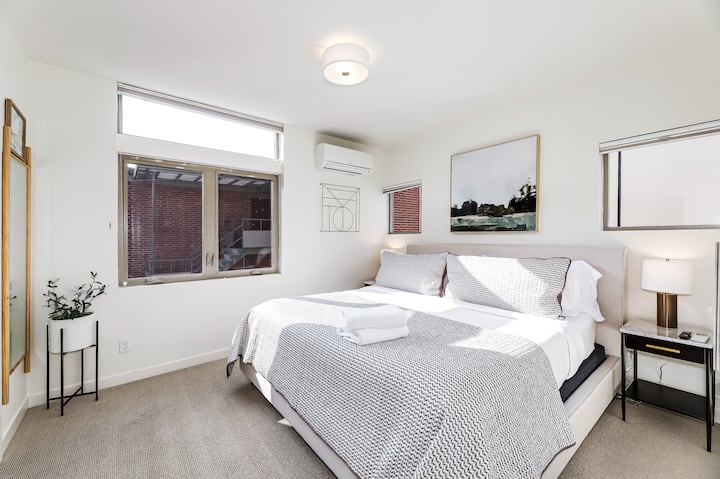 Dormitorio principal soleado en la planta superior con colchón de espuma viscoelástica tamaño king y sistema de aire acondicionado de conducto dividido.