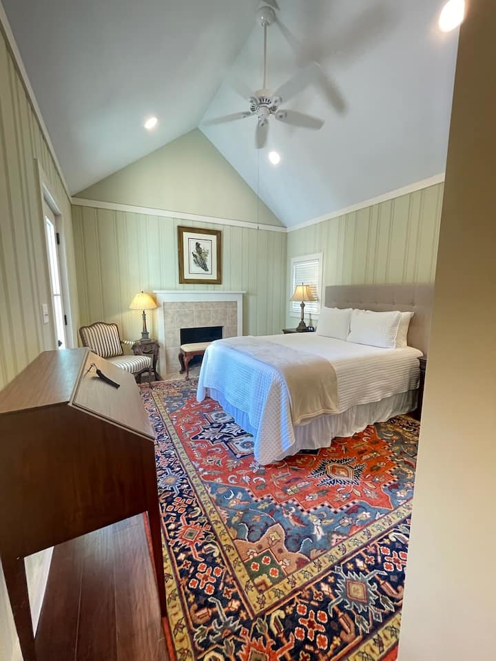 Una cama tamaño queen con zona de estar y acceso privado al patio.