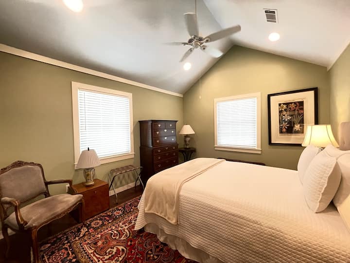 Una cama tamaño queen con un acogedor espacio para sentarse. 