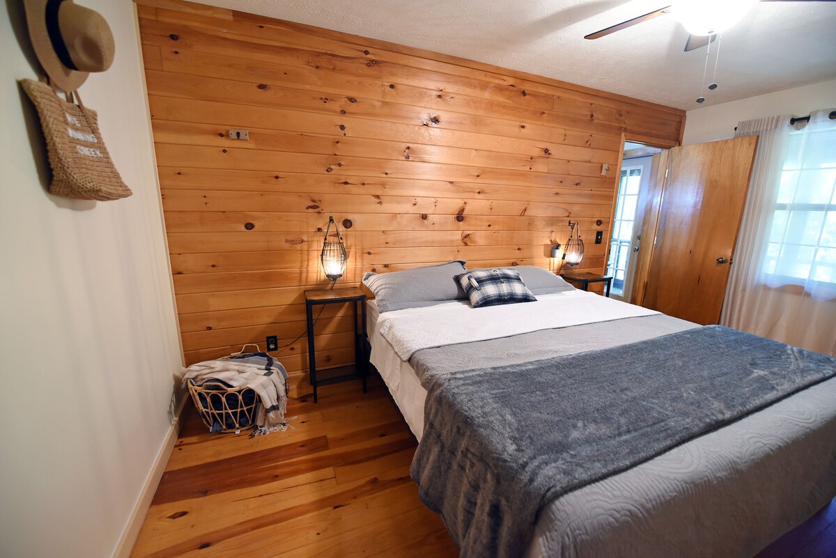 Ropa de cama tamaño king en el piso principal con TV inteligente