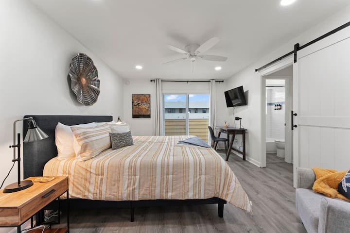 Large primary bedroom with King bed, workstation, reading nook and outdoor balcony