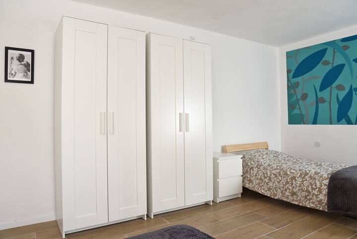 The bedroom with 2 single beds. 
Each guest has an abatjour on the bedside table, with 2 drawers, and a closet with hangers inside.
The hangers? Are there;-)