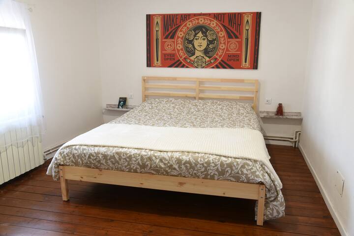 The double room has the original wooden floor, which has been treated and repainted. On the wall a reproduction on wood of the work MAKE ART NOT WAR by Obey.  Each guest has a power outlet near the bed, for chargers.