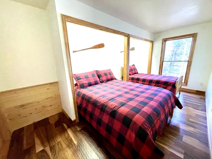 Dormitorio con camas dobles e individuales, vistas al lago.