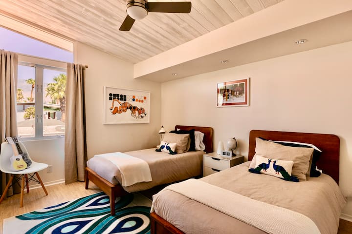 The Tiger Room
Two plush Green Tea twin beds, high ceilings & stunning San Jacinto Mountain views make this retreat perfect for kids & adults alike. Anchored by a striking tiger mural, it exudes a touch of untamed charm.