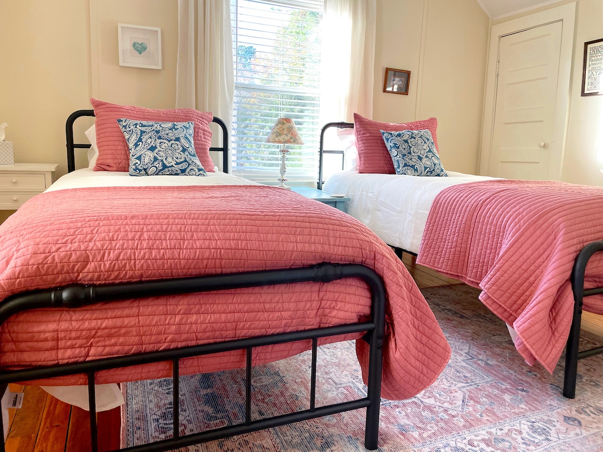 חדר שינה לאורחים עם מיטות זוגיות בקומה השנייה