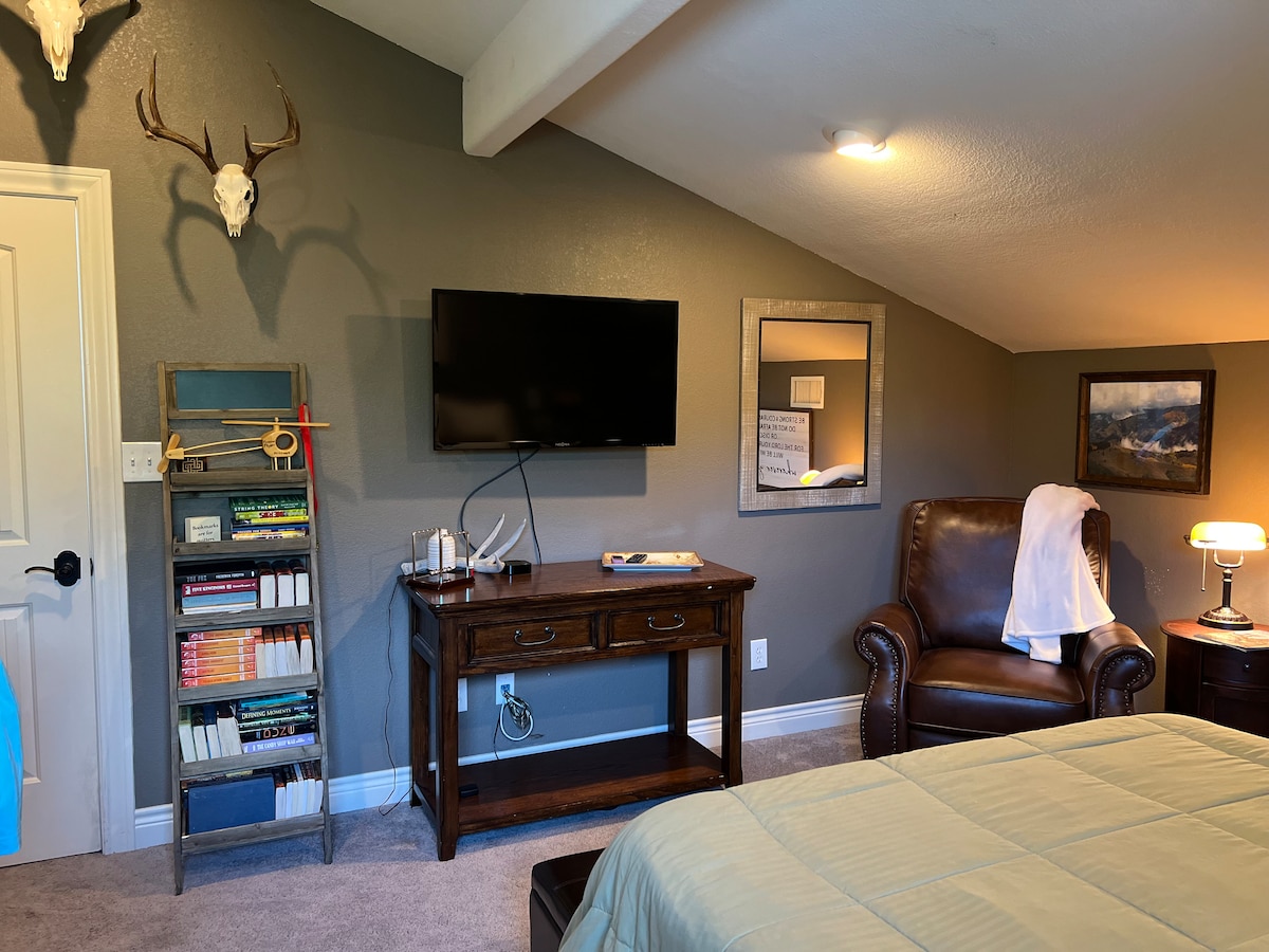 ผ่อนคลายในห้องแอนท์เลอร์ห้องใต้หลังคาแสนอบอุ่นของเราพร้อมเบาะหนัง อ่านหนังสือหรือดูทีวีความคมชัดสูง 40 นิ้ว