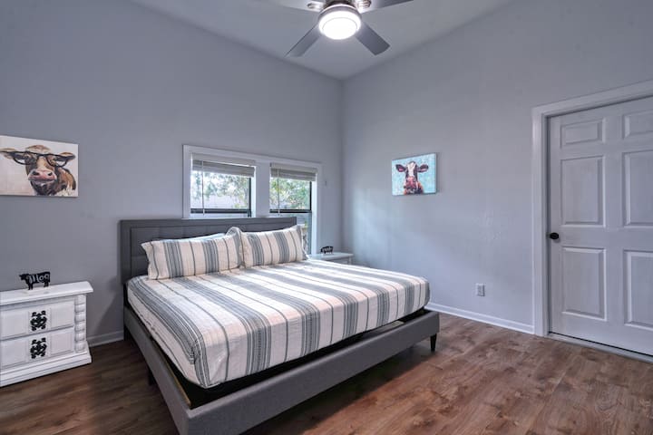 חדר שינה קינג סייז עם שידה, שידת לילה וממש ליד זה הוא חדר רחצה עם שירותים. 